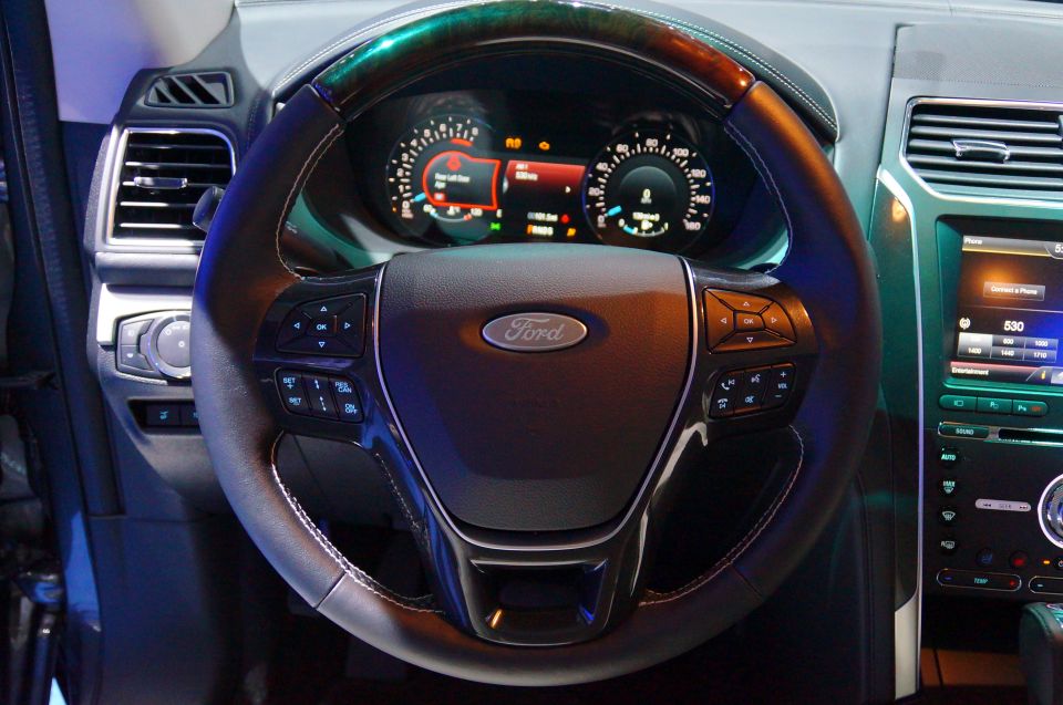 Interior view of a Ford vehicle showing the steering wheel, digital dashboard, and center console.