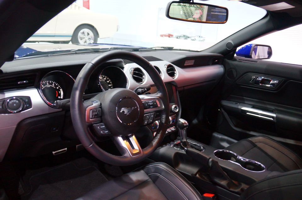 Interior of a modern Ford Mustang, showing steering wheel, dashboard, and center console.