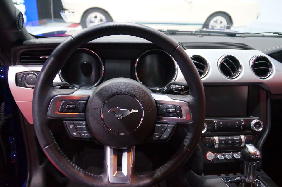 Interior of a Ford Mustang, showing the steering wheel, dashboard, and center console.