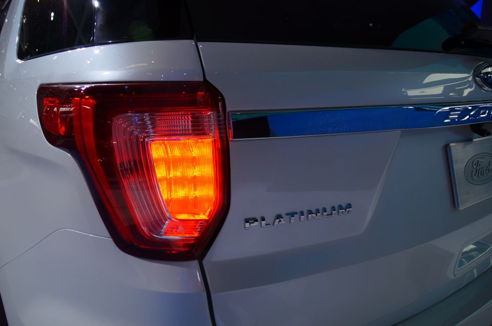 Close-up of a white Ford Explorer Platinum's illuminated rear right taillight and badging.