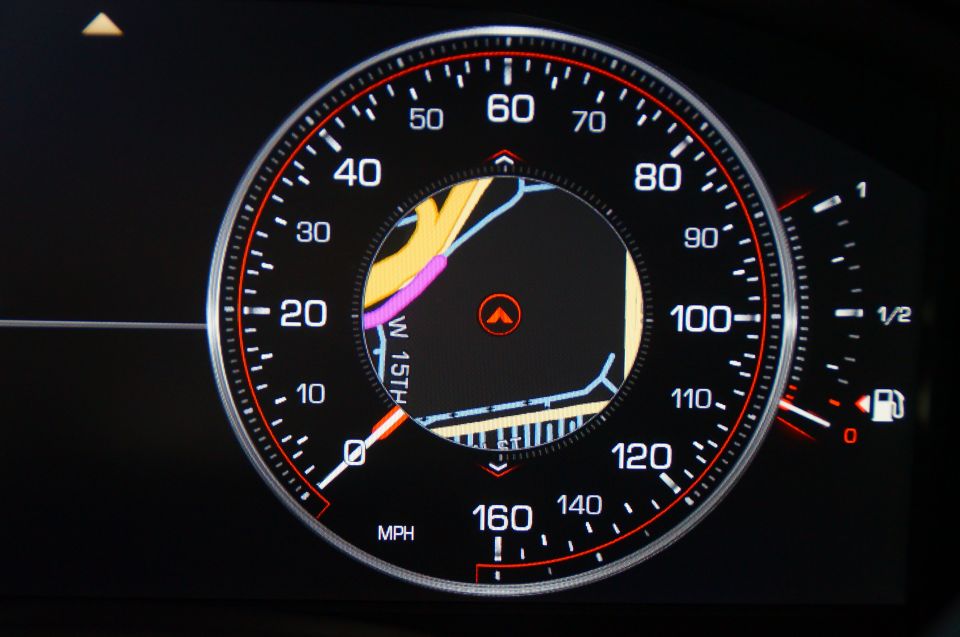Digital car dashboard showing speedometer and navigation map.