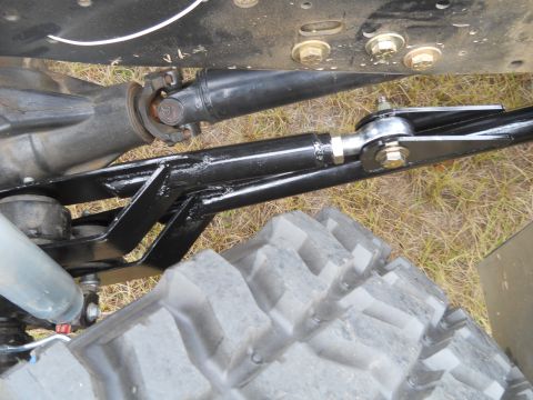 1992 Ford Bronco - A close-up view of the suspension and drivetrain components of a 1992 Ford Bronco, showing a black metal tie rod assembly connecting to the…
