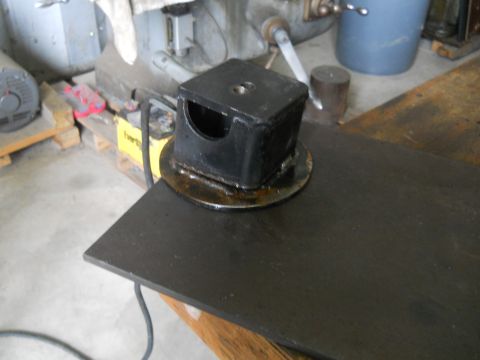 1992 Ford Bronco - A black metal fabricated part with a circular base sits on a dark metal surface. The part has a square top with a circular cutout on one si…