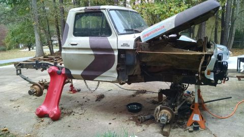 1979 Ford F-150 - This pickup truck is undergoing repairs with its front end disassembled and supported by jack stands.