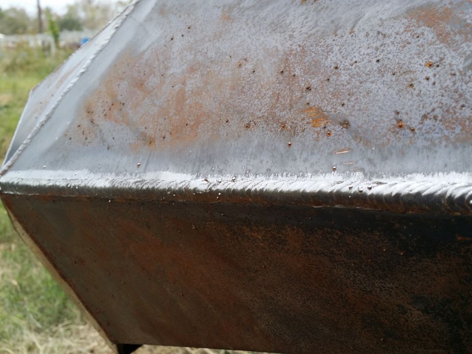 Close-up of a rusty, angular metal object with visible weld lines