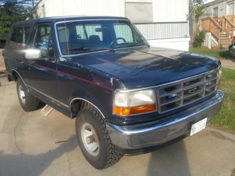 1993 Ford Bronco - This 1993 Ford Bronco features a prominent chrome grille and a Texas license plate, seen from a three-quarter front perspective.