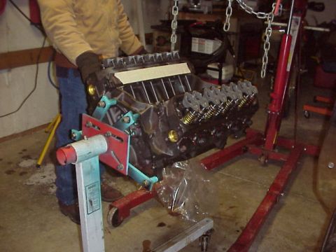 1989 Ford Bronco - Engine being worked on in a garage setting, suspended by chains and a red engine hoist.