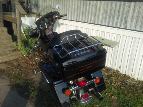 1993 Ford Bronco - Rear view of a Harley-Davidson motorcycle parked outdoors next to a building.