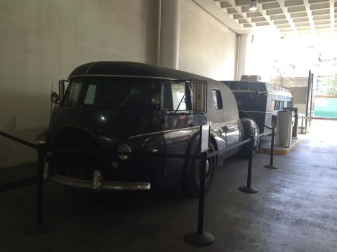 1968 Ford Mustang - A dark-colored, custom van with a distinctive rounded roofline is displayed alongside another vehicle.