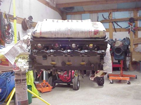 1989 Ford Bronco - Engine block and components are visible in a workshop setting, covered with newspaper for protection.