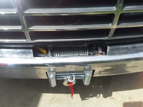 1993 Ford Bronco - A winch is installed on the front bumper of a vehicle, with a portion of the chrome grille visible above.