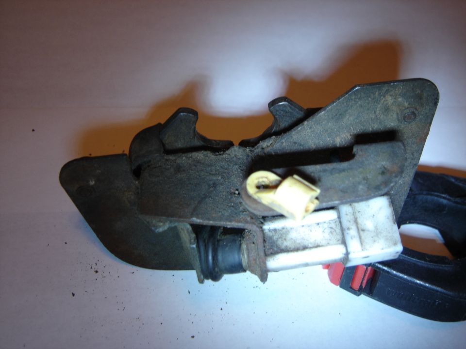 close-up of a vehicle door latch mechanism with a yellow connector