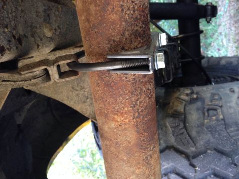 1979 Ford Bronco - Close-up view of a rusty suspension component and a clamp, with a tire tread visible in the background.