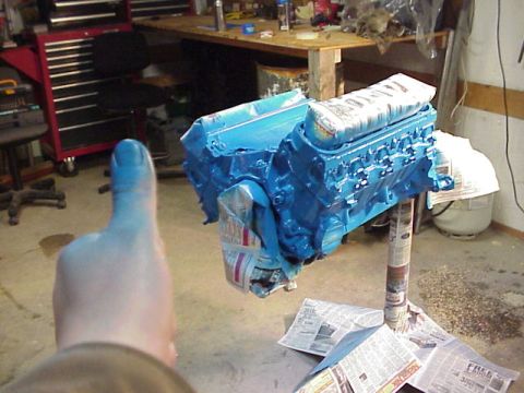 1989 Ford Bronco - A blue engine is mounted on a stand, covered in plastic wrap and newspaper for protection.