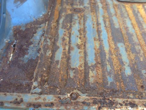 1979 Ford Bronco - Close-up of a heavily rusted floor pan, showing significant corrosion and wear.