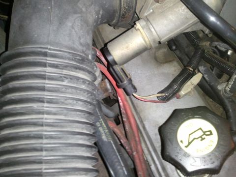 1990 Ford Bronco - A view of engine components including the air intake system and an oil fill cap.