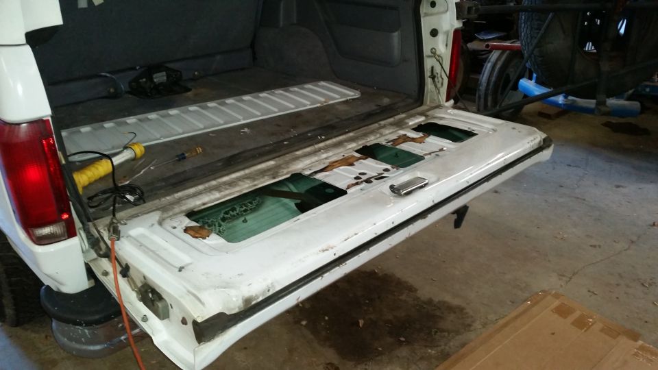 White 1995 Ford Bronco tailgate with broken glass panels
