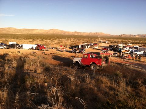 1995 Ford Bronco - A group of off-road vehicles are gathered in a desert landscape under a clear blue sky.