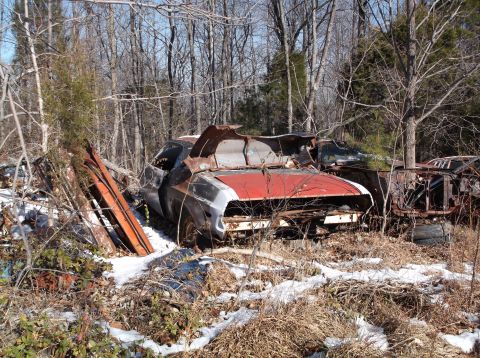 1974 Dodge Challenger - Junkyard scene with a heavily damaged 1974 Dodge Challenger and other vehicles.