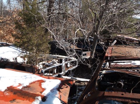 1974 Dodge Challenger - Multiple wrecked vehicles are visible in a junkyard setting with snow on the ground.