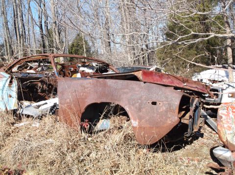 1974 Dodge Challenger - This 1974 Dodge Challenger is in rough shape, sitting in a junkyard with other vehicles.