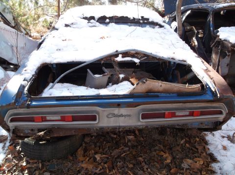 1974 Dodge Challenger - Abandoned 1974 Dodge Challenger sits in the snow, showing its rear end and taillight panel.