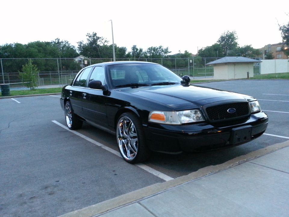 Black 2006 Ford Crown Victoria with chrome wheels parked in a lot