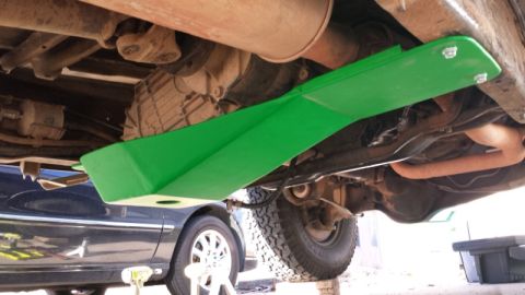 1993 Ford Bronco - The undercarriage of a 1993 Ford Bronco is visible, fitted with a bright green skid plate.