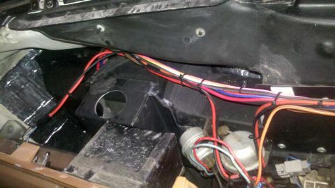 1982 Ford Bronco - A close-up view of the complex wiring system located beneath the dashboard of a vehicle.