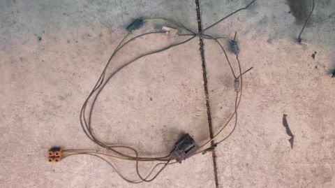 1982 Ford Bronco - A vehicle wiring harness is shown on a concrete floor, disconnected from any vehicle.
