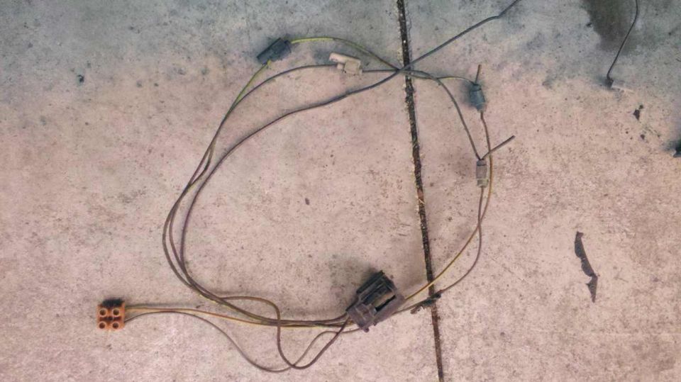Wiring harness with multiple connectors and brown wires laid out on a concrete surface