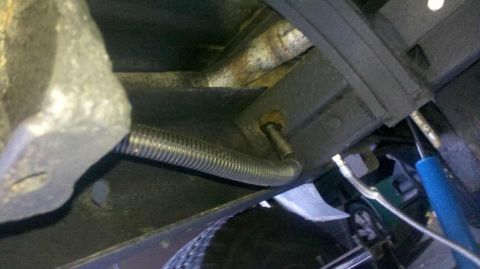 1982 Ford Bronco - Close-up of the undercarriage showing a flexible conduit and suspension components.