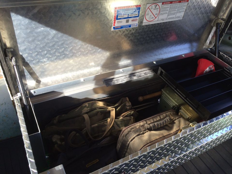 Diamond plate truck bed tool box interior with bags and ammo can