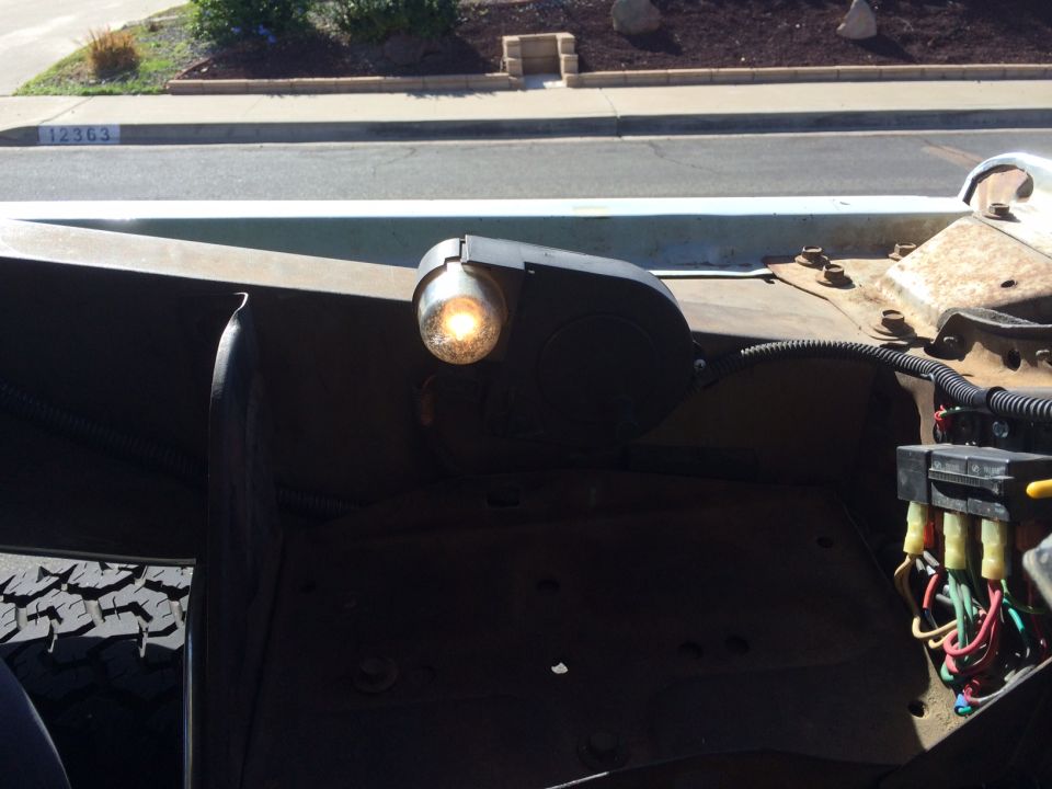 close-up of a truck's fender with a turn signal light and fuse box