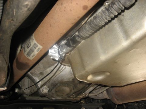 1994 Ford Bronco - Underneath a vehicle, a driveshaft is visible with a label that reads 'NL2'. A section of the driveshaft is wrapped in aluminum tape and se…