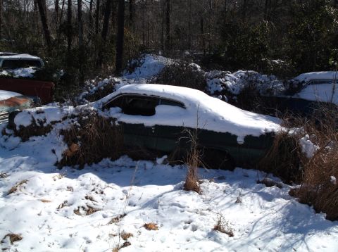 1974 Dodge Challenger - A car sits partially covered in snow, with another vehicle visible in the background.