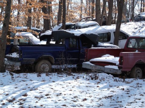 1974 Dodge Challenger - Multiple vehicles are seen in a snowy junkyard environment.