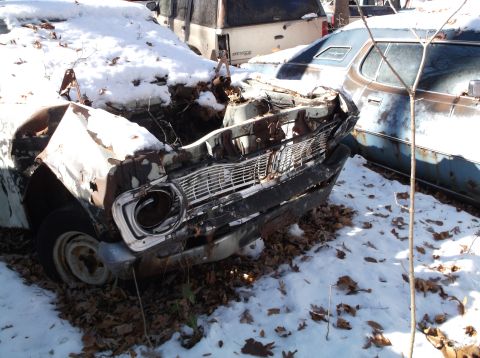 1974 Dodge Challenger - This car's front end is severely damaged and covered in snow, with another vehicle nearby.