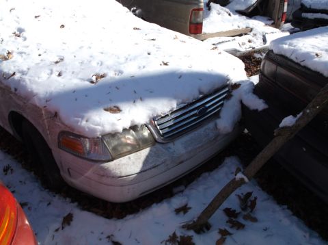 1974 Dodge Challenger - White Ford Crown Victoria sits buried in snow next to another car.