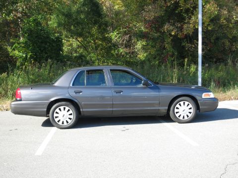 2001 Ford Crown Victoria - Side profile of a grey 2001 Ford Crown Victoria sedan parked outdoors.