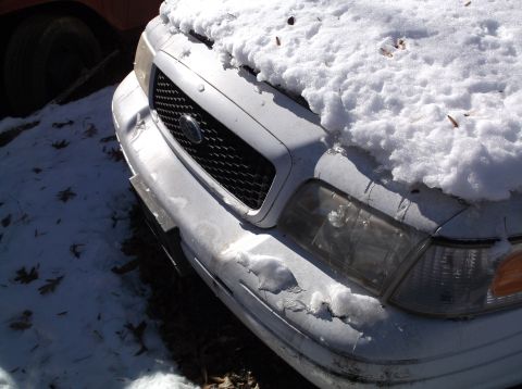 1974 Dodge Challenger - A white sedan sits in the snow, its front end damaged and covered in ice.