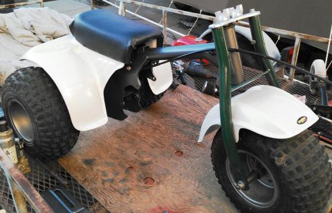 1900 Honda Big Red - This three-wheeled ATV is white with a black seat and green front forks.