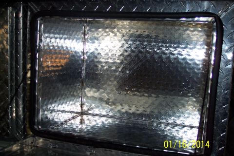 1973 Ford F-250 - Interior of a diamond plate aluminum storage compartment with a rubber seal around the opening.