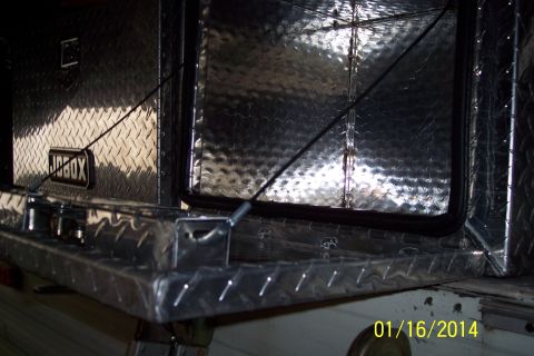 1973 Ford F-250 - Diamond plate Jobox tool chest with visible latches and cables, mounted on the bed of a white truck.
