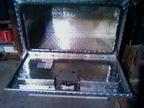 1973 Ford F-250 - Aluminum underbox with lid open, revealing diamond plate interior and mounting hardware. Labels are visible inside.