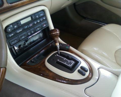1998 Ford Crown Victoria - Close-up of the automatic gear shifter and center console, wood trim and leather upholstery.