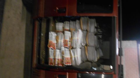 2000 Chevrolet Astro - The interior of a red vehicle, likely a van, is filled with stacks of bundled newspapers. The bundles are tied with yellow bands and are ti…