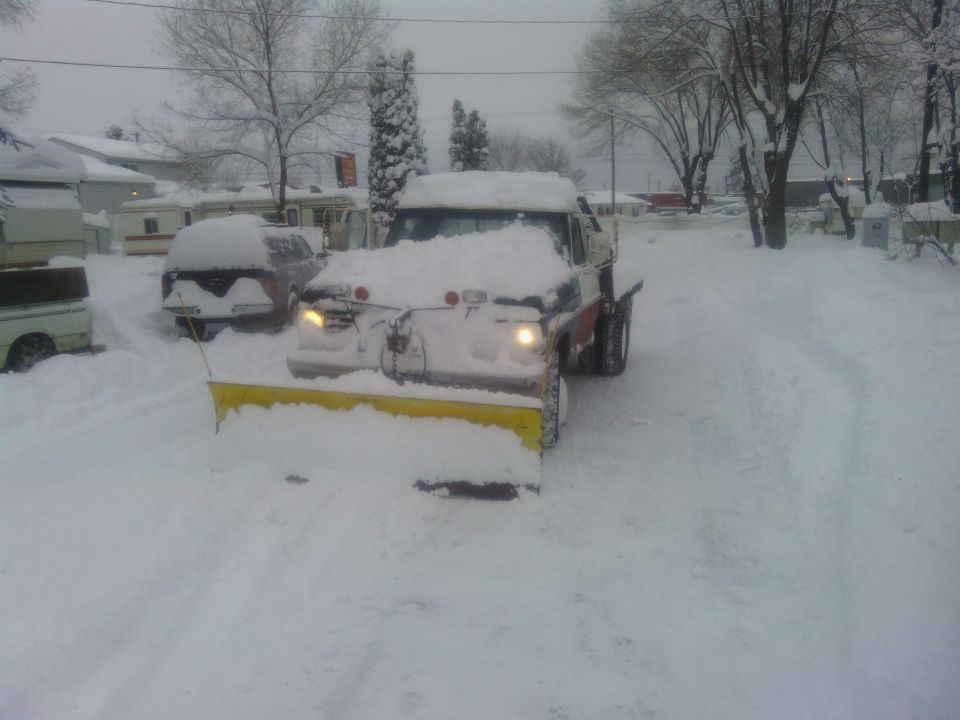1972 Ford F-250 with a snow plow in a snowy driveway.