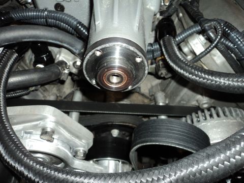 2004 Mercury Grand Marquis - A close-up view of a supercharger assembly and serpentine belt system in a vehicle engine bay. The polished metal components and black brai…