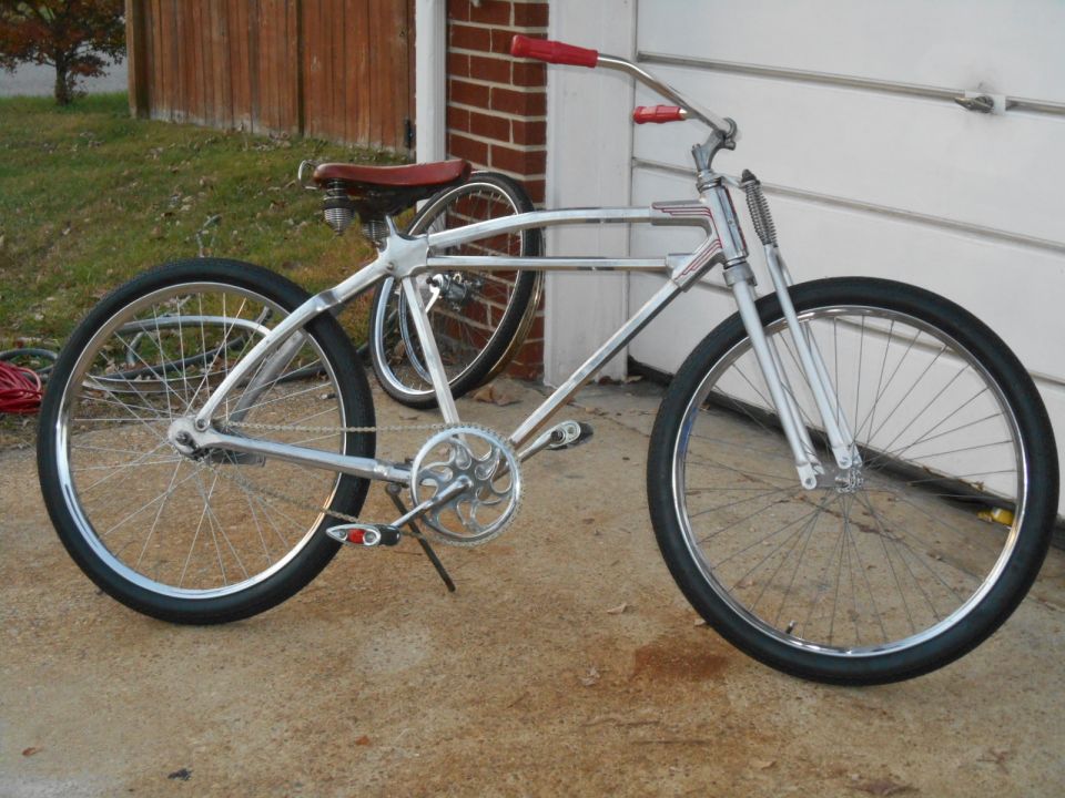 Vintage chrome bicycle with red handlebars and seat